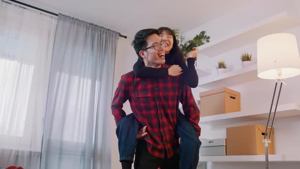 Boyfriend Giving Piggyback Ride To His Girfliend While She Holds Keys of New Appartment
