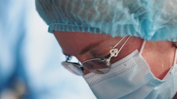 Closeup of a Female Doctor's Eyes Through a Protective Mask and Medical Glasses