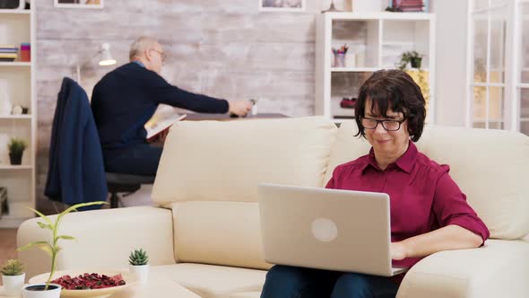 Senior Woman with Glasses Working on Laptop