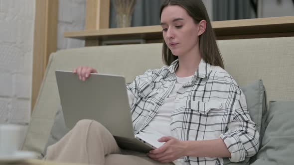 Young Woman Closing Laptop and Going Away From Sofa