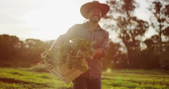 Happy young farmer walking in fields