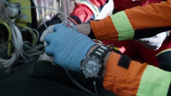 Crop Paramedic Putting Oxygen Mask on Patient