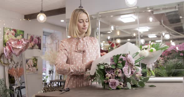 Caucasian Florist Wrapping Bouquet In Decorative Paper