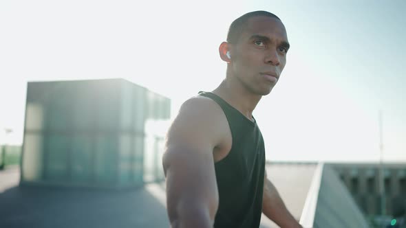 Bald confident sportsman wearing black T-shirt looking at the view outdoors