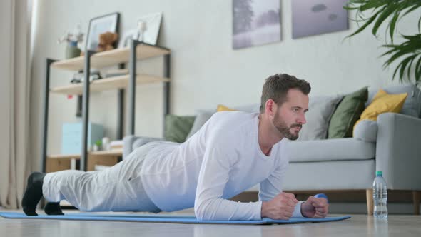 Man Doing Plank on Yoga Mat at Home