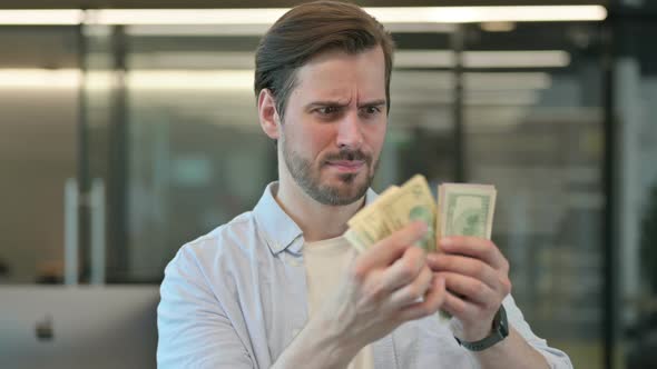 Portrait of Man Feeling Worried Counting Dollars