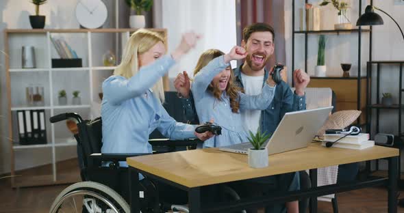 Woman in Wheelchair After Accident, Her Cute 10-Aged Daughter and Loving Bearded Husband Having Fun