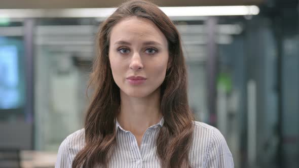 Portrait of Serious Young Woman Looking at the Camera  in Cafe