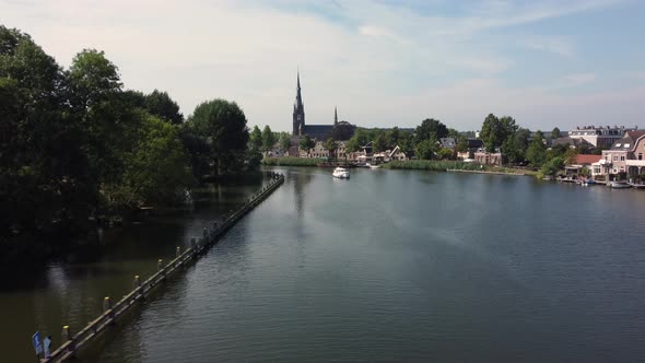 City Weesp in Holland flying over river Vecht towards church