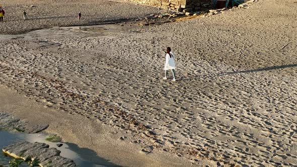 A girl walks on the beach 4 K Aerial View