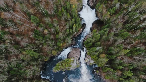 Aerial shot of autumn forest and running water between the shores in Aguasabon Falls,Ontario,Canada