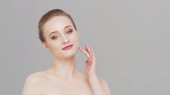 Studio portrait of young, beautiful and natural woman over grey background.