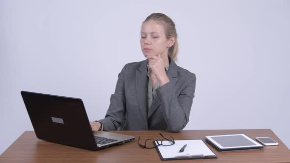 Young Beautiful Blonde Businesswoman Using Laptop and Looking Shocked at Work