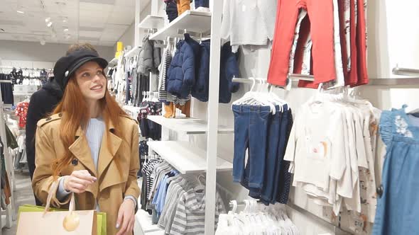 Happy Married Couple Choosing Clothes in Shopping Store