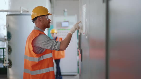 Concentrated man engineer in uniform working at a power plant