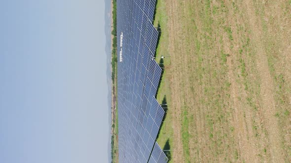 Vertical: aerial shot of solar farm panels generating natural energy from sun