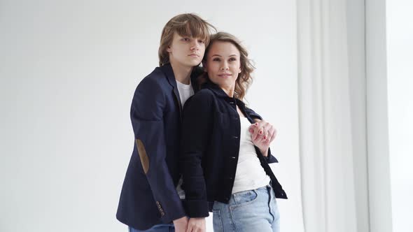 A Mother with Son in Blue Clothes Poses By the Window for a Photo Shoot