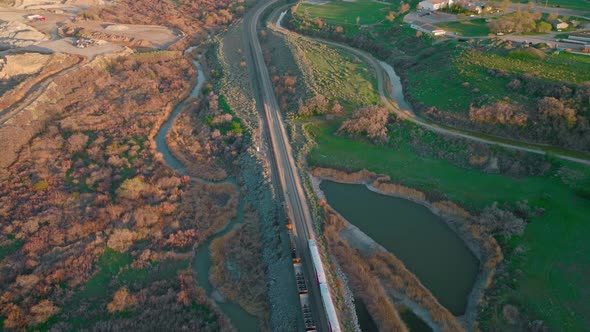 AERIAL - Train on railroad tracks near Bluffdale, Utah, forward approach