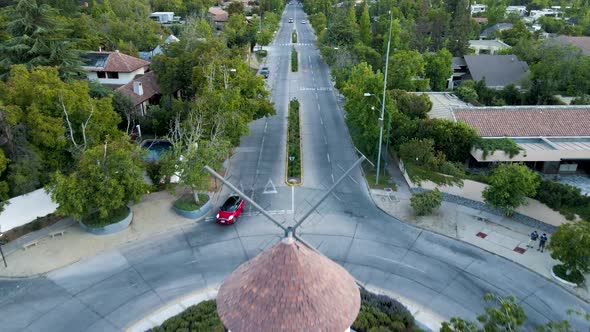 Aerial dolly in of Leonidas Montes windmill in roundabout with cars driving in avenue surrounded by