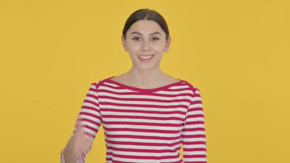 Thumbs Up by Spanish Woman on Yellow Background