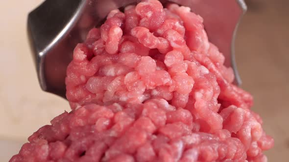 Filling Comes Out Through a Meat Grinder Sieve. Meat Grinder Close Up, Pile of Chopped Meat, Mincer