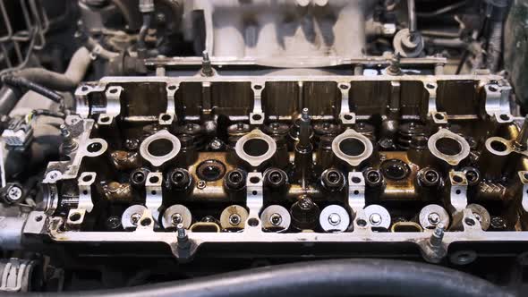 Disassembled car engine in oil. Cylinder head of an automobile engine. Refurbished car inside. Sixte