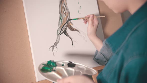 A Young Woman Artist Painting Tree Trunk in Darker Color