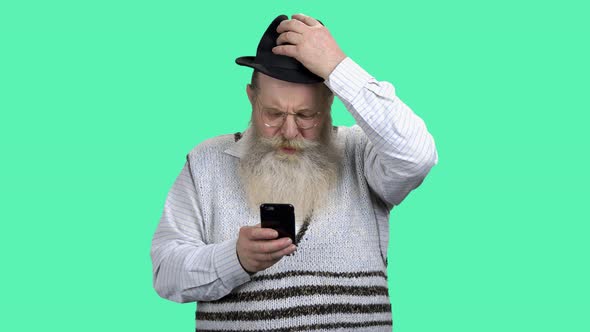 Portrait of Senior Man Surfing Internet on Mobile Phone.