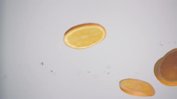 Fresh orange slices in circle shape passing over in front of the camera in slow motion