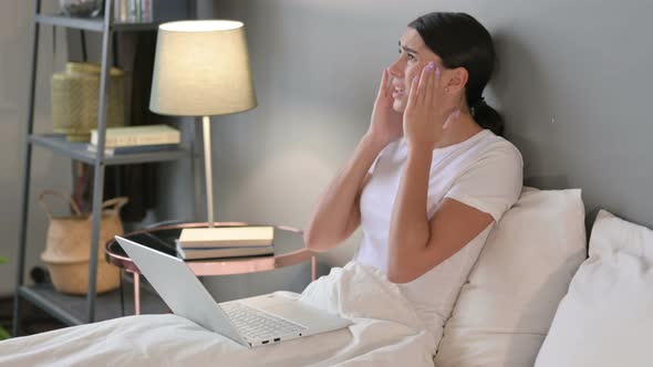 Young Latin Woman with Laptop Having Loss in Bed 