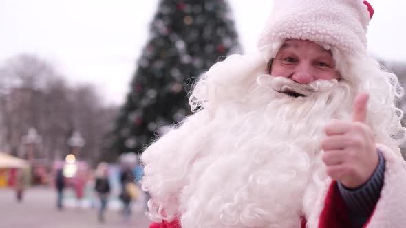 Stylish Santa Claus with a White Beard in a Red Suit Showing Thumb Up Merry Christmas 2023