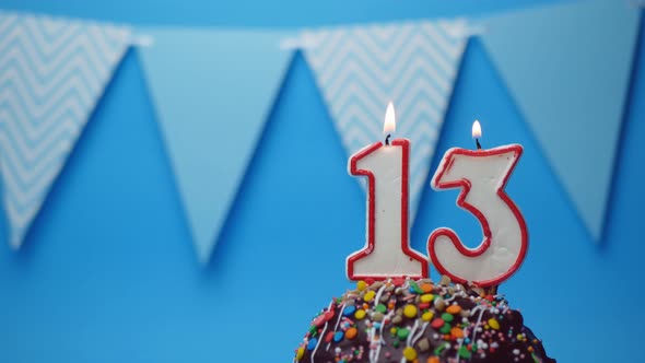 Happy birthday greetings.13 years old, cupcake, birthday cake with birthday candles on a blue backgr alt