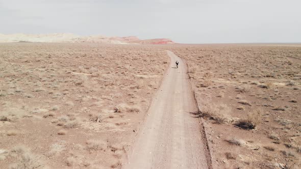 Drone Shot of Bicyclist Ride in Canyon Desert Mountains in Kazakhstan