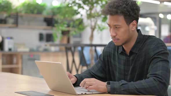 African American Man with Laptop Thinking at Work