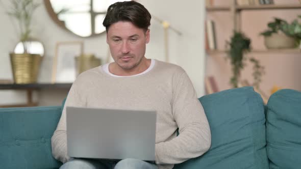 Middle Aged Man Working on Laptop at Home