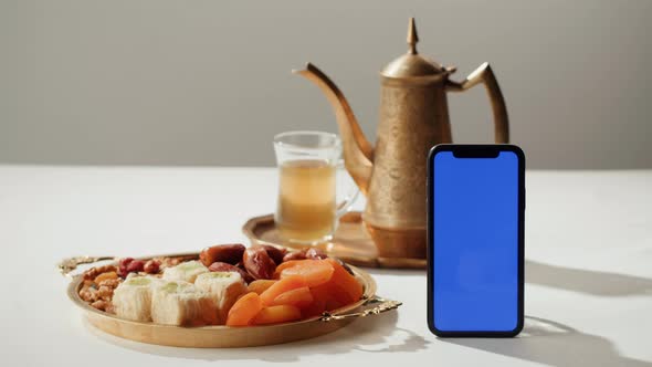 Turkish Tea and Sweets Smartphone with Blue Chroma Key Screen Hot Drink in Traditional Armudu Glass