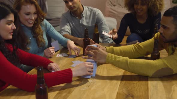 Millennial adult friends socialising together at home