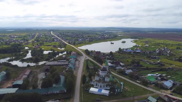 Aerial view of Church in the village. Near the river, bridge and pond