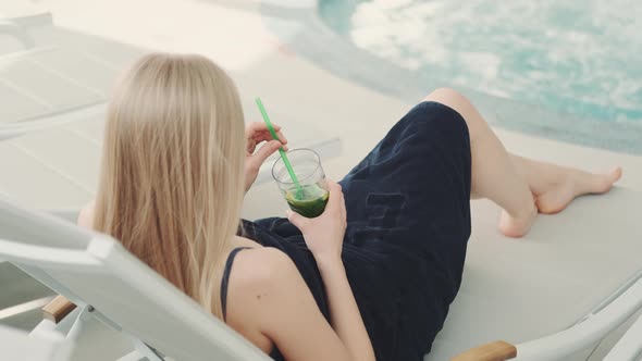 Back View of Blonde Women Lying on Desk Chair in Sparesort