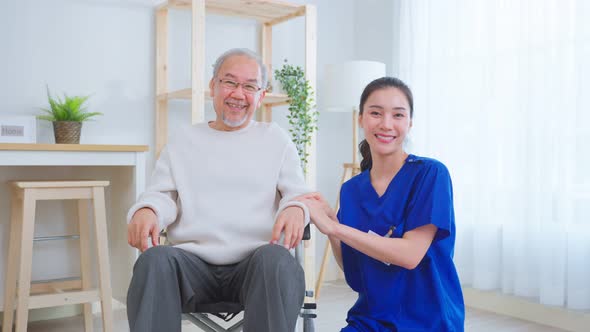 Portrait of Asian caregiver nurse take care senior male on wheelchair.