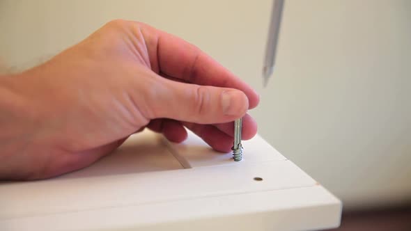 Man Spins Retaining Bolt Into the Wall Wardrobe