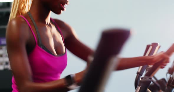 Fit woman exercising on cross trainer