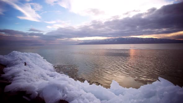 Timelapse of sunset over utah lake as ice sheets float by.