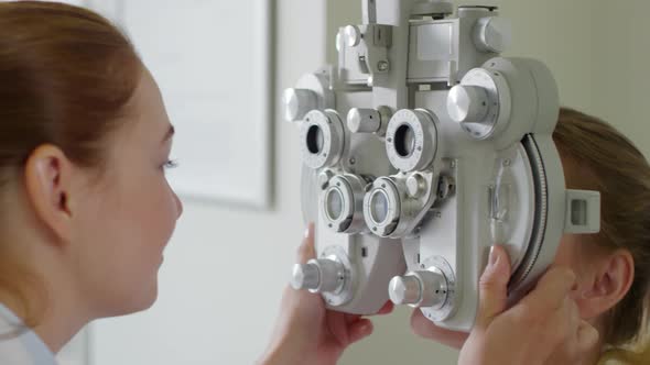 Optometrist Using Phoropter to Check Eyesight of Patient