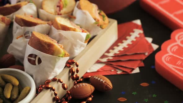 Game day football party table with  sub sandwich and snacks.