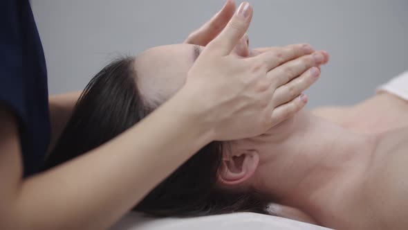 Woman Massagist Doing a Face Massage Using Her Fingers on the Clean Skin of Her Female Client