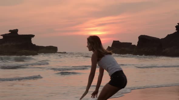 Female Tourist Walking to Ocean and Touching Water