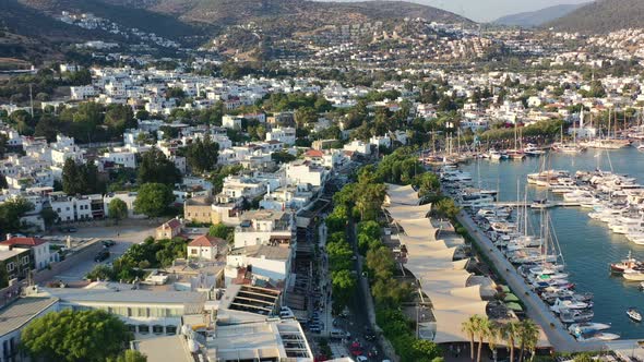 aerial drone overlooking the main walking street in Bodrum near the marina with many white villas in