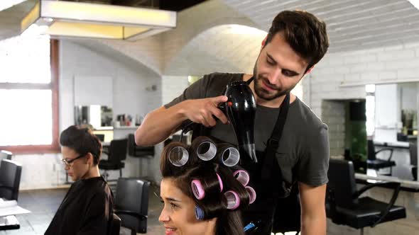 Male hairdresser styling customers hair