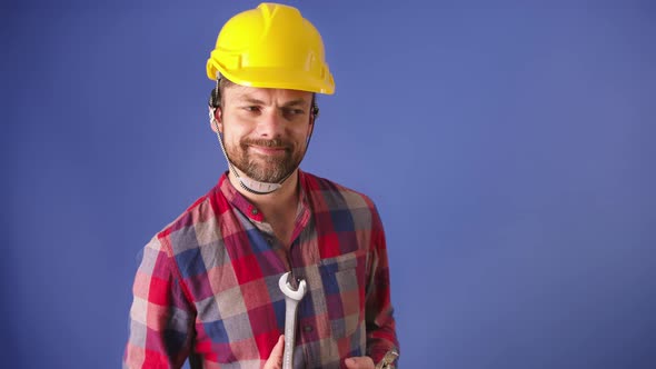 Young Man with a Hard Hat Checking His New Tools. Smiling When Quality Is Confirmed. Slow Motion